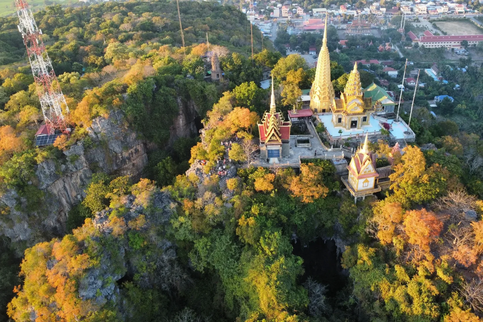 A golden pagoda above a wooded hillside near Battambang.