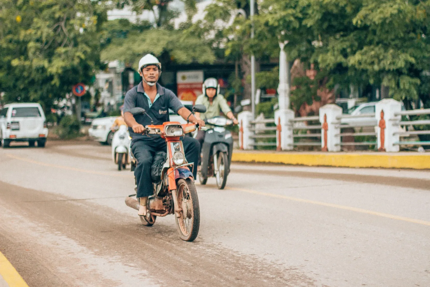 Motorcyclists travelling along a street in Siem Reap.